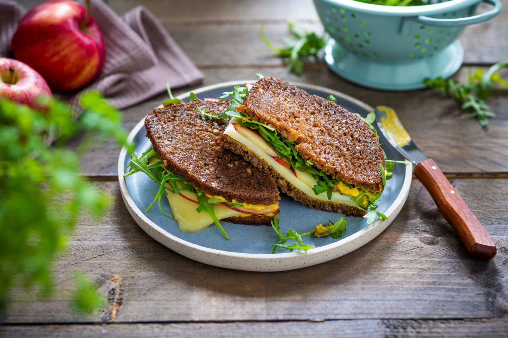 Schwarzbrot belegt mit Käse, Apfel, Rucola und Senf