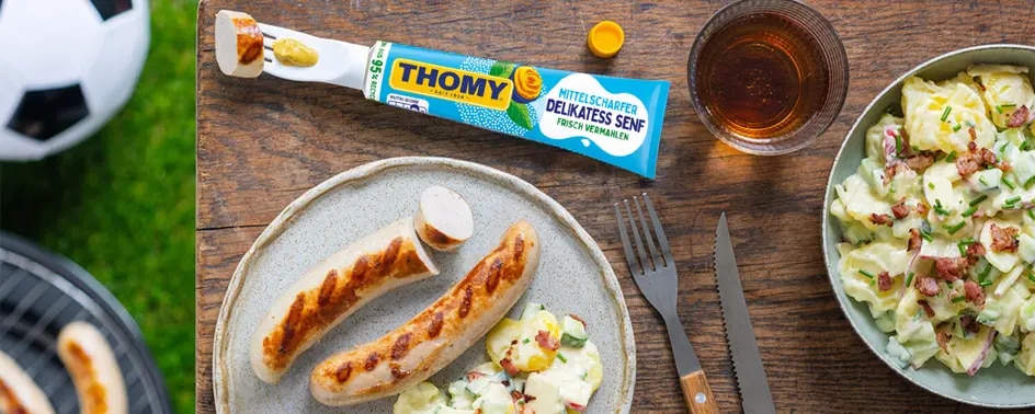tisch mit bratwurst und einer tube senf mit the Saurk